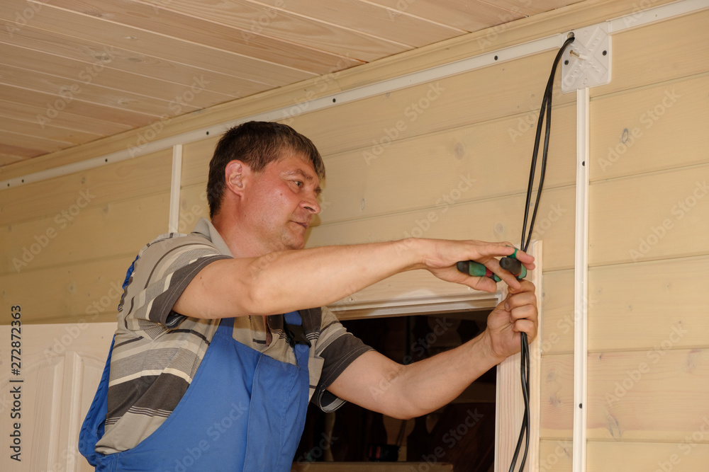 electrical engineer performs installation of electrical wiring inside a