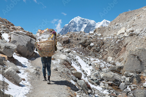 Nepal Porter carrying heavy load on his back.