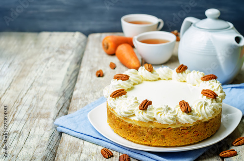 carrot cake cheesecake with pecan on a wood background