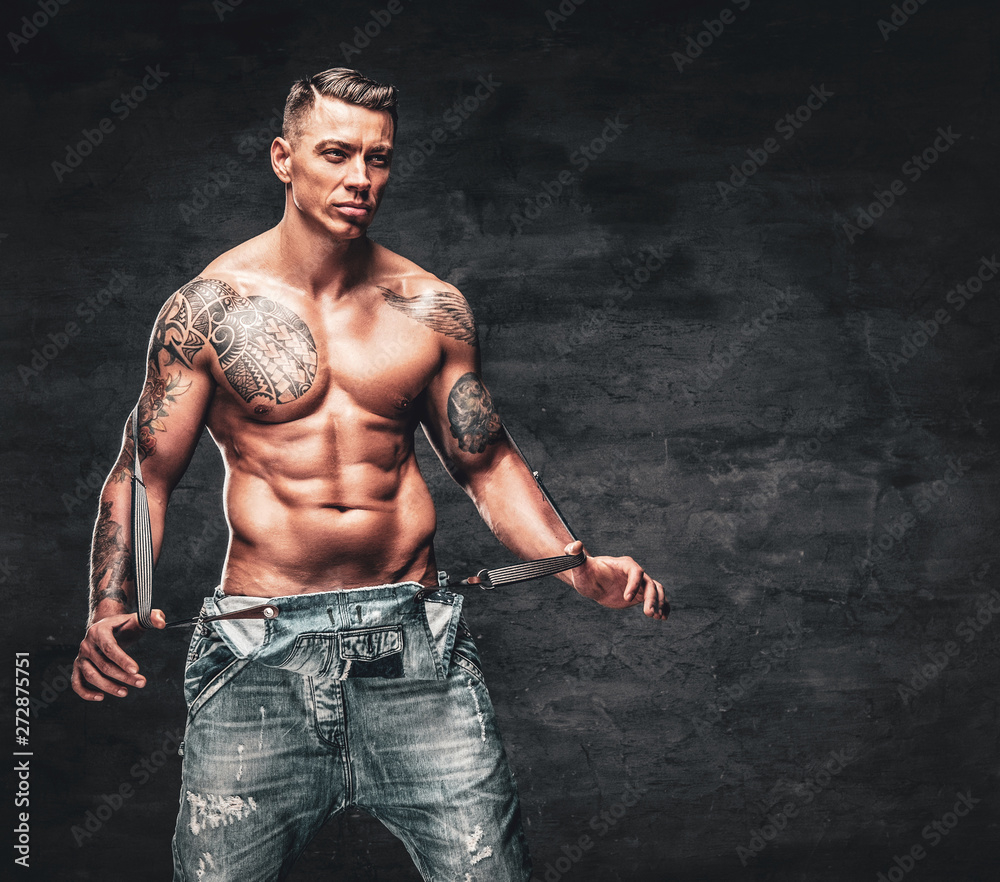 Tattoo model with sexy belly. Man with tattooed arm and chest. Bearded man  with strong torso. Sportsman or athlete in fashion jeans. Bodycare with  fitness and sport Stock Photo by ©stetsik 198275980