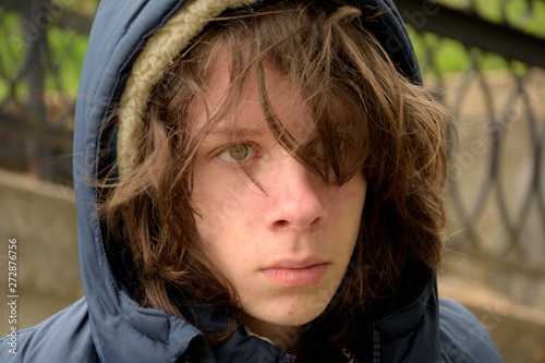 teenager boy with long hair looking upset and distracted