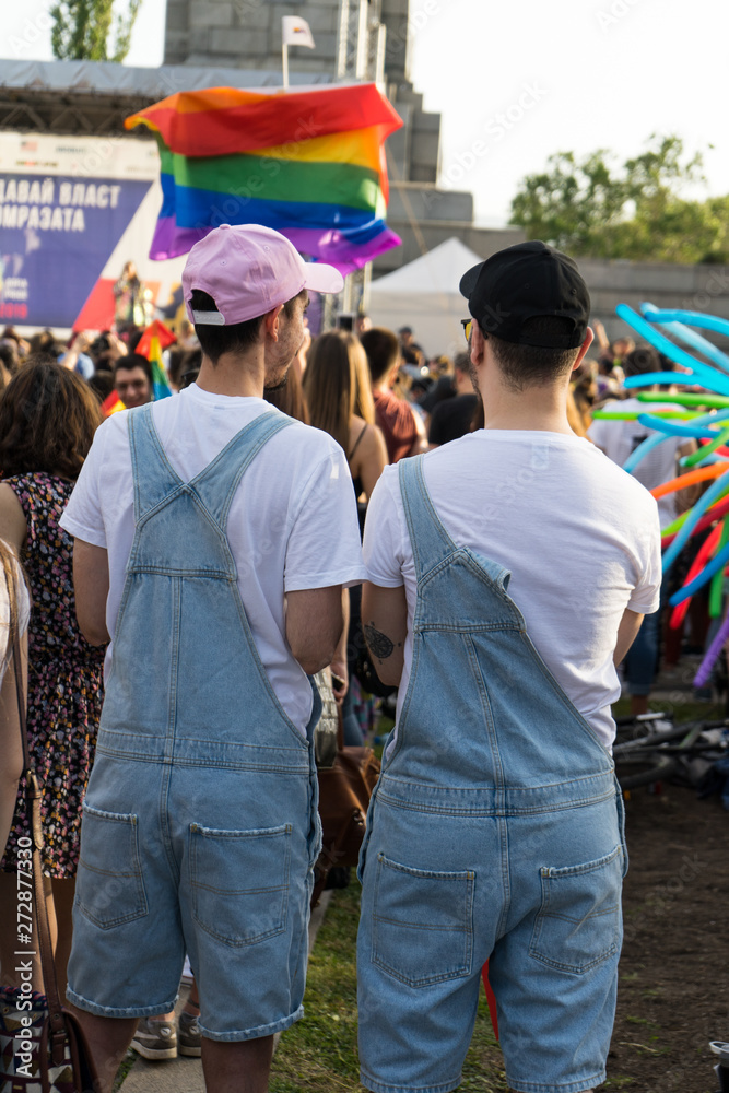 Obraz premium Gay couple in a concert enjoying the pride festival in Sofia. Homosexual partners with same clothes and hats