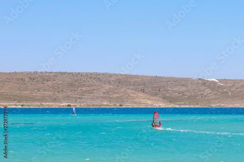 Windsurfer sails on turquoise waters of Alacati Windsurf Bay of Cesme, Turkey. photo