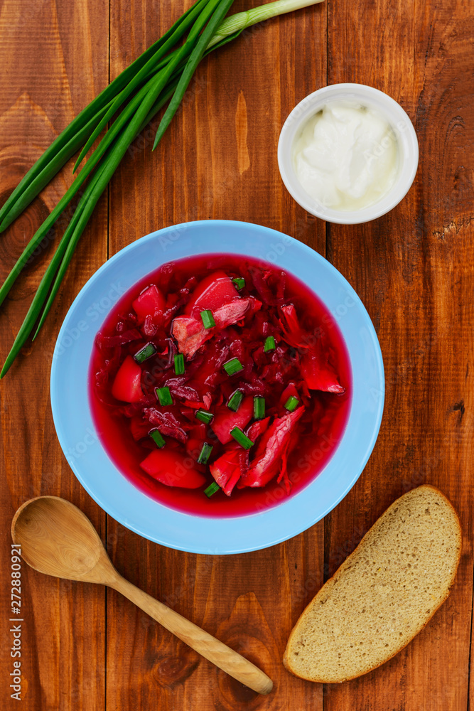 Borsch in a plate on a wooden table. Traditional, national russian soup. Borsch in a plate on a wooden table. Traditional, national russian soup.