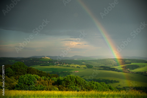 Rainbow in green summer nature, beautiful evening sunset light, summer rural landscape
