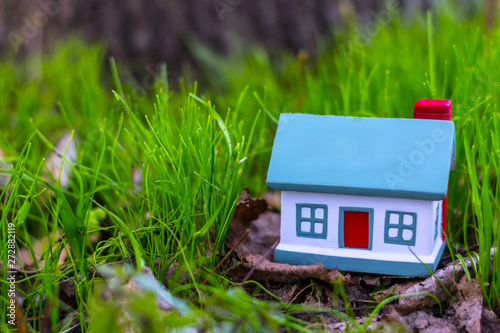 Small model of house over green grass background.