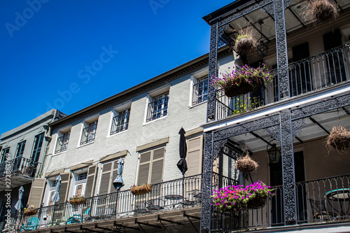 Charming Balconies with Wrought Iron and Flower Baskets overlook the Popular Streets below in the French Quarter of New Orleans, Louisiana, USA