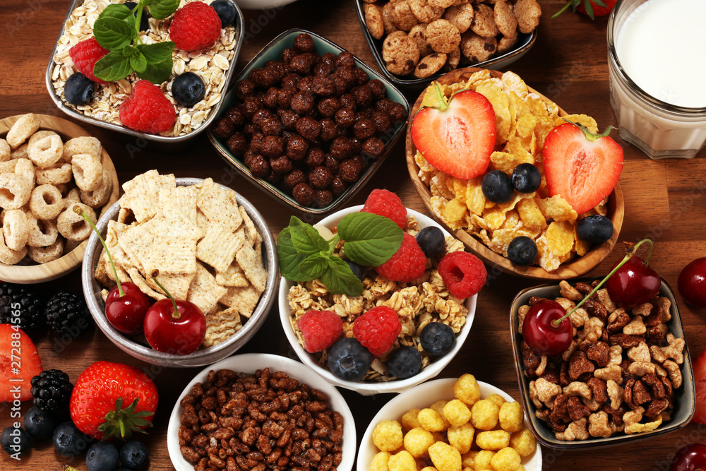 Cereal. Bowls of various cereals, berries and milk for breakfast. Muesli with kids cereals.