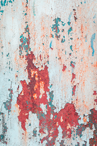 Old grungy cracked blue and red weathered wall paint peeling off rusted metal sheet. Textured background for posters and bloggers