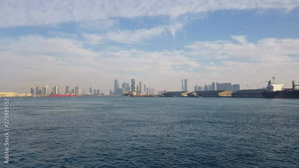 Sea port and view of the city with skyscrapers on the horizon. Sea port with moored ships. Skyscrapers on the background of blue sky. Sea port and view of the city with skyscrapers on the horizon. Sea port with moored ships. Skyscrapers on the background of blue sky.