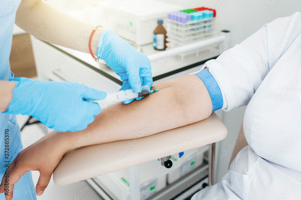 Nurse taking blood sample from patient at the doctors office Stock