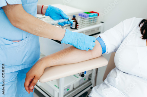 Nurse taking blood sample from patient at the doctors office © andrew_shots
