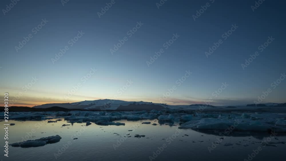 Timelapse of Glacier Lagoon / Jökulsarlón at sunrise with icebergs and clouds in view