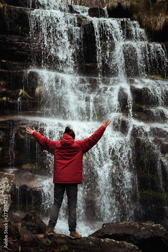 Girl in red jacket by the waterfall