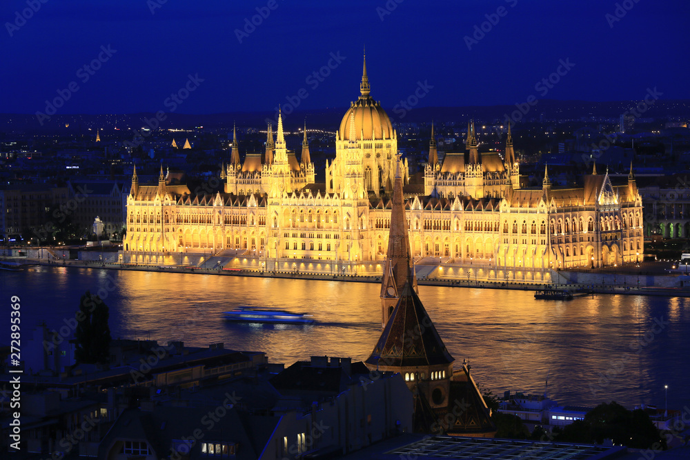 Beautiful night view of the Hungarian Parliament building and the Danube river with lights in the water in Budapest, Hungary