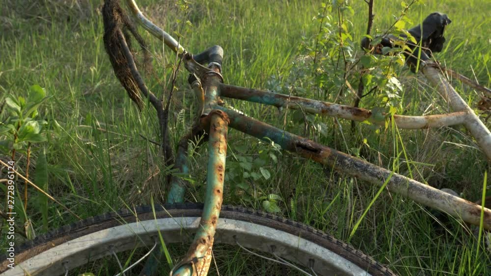 Close shot of a rusty bike in the forest with a slow motion pan to the right. Close shot of a rusty bike in the forest with a slow motion pan to the right.