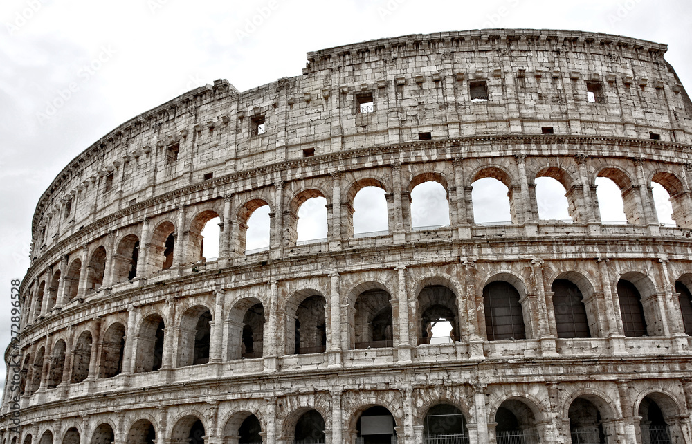 Ancient architecture. The Coliseum is an oval amphitheatre in the centre of the city of Rome, Italy. It is the largest amphitheatre ever built. Landmarks of Italy.