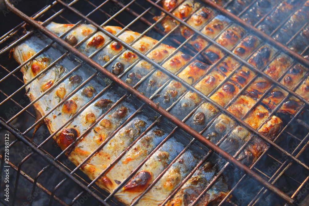 Cooking mackerel fish on the grill. Close-up. Background.