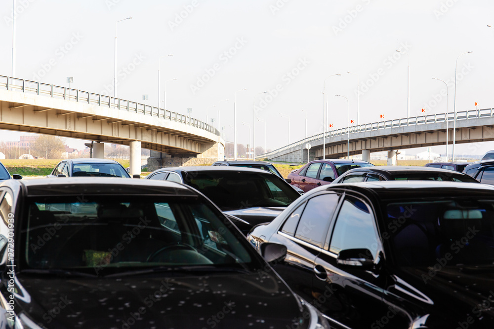 cars in the street parking on the background of a flyover