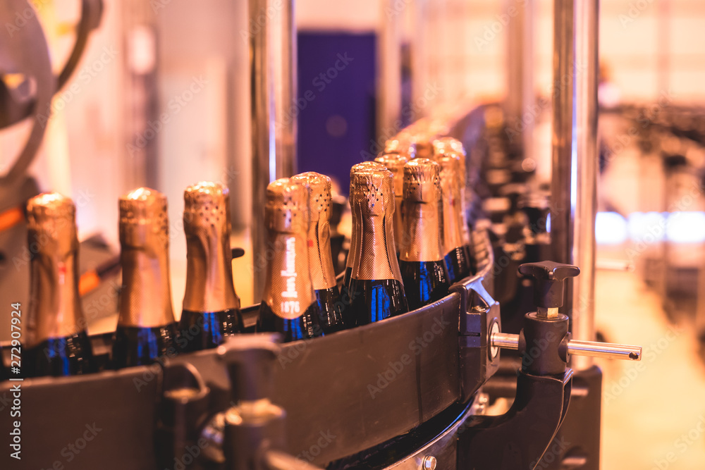 View of glass bottles on the conveyor belt, bottle necks on the production line, brewery equipment, inside wine factory, process of alcohol liquor manufacture production View of glass bottles on the conveyor belt, bottle necks on the production line, brewery equipment, inside wine factory, process of alcohol liquor manufacture production
