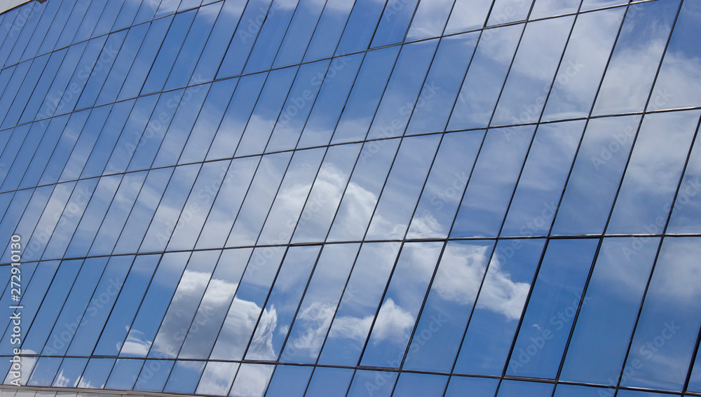 reflection of the sky with clouds in the glass windows of the building