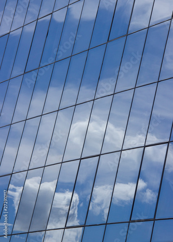 reflection of the sky with clouds in the glass windows of the building