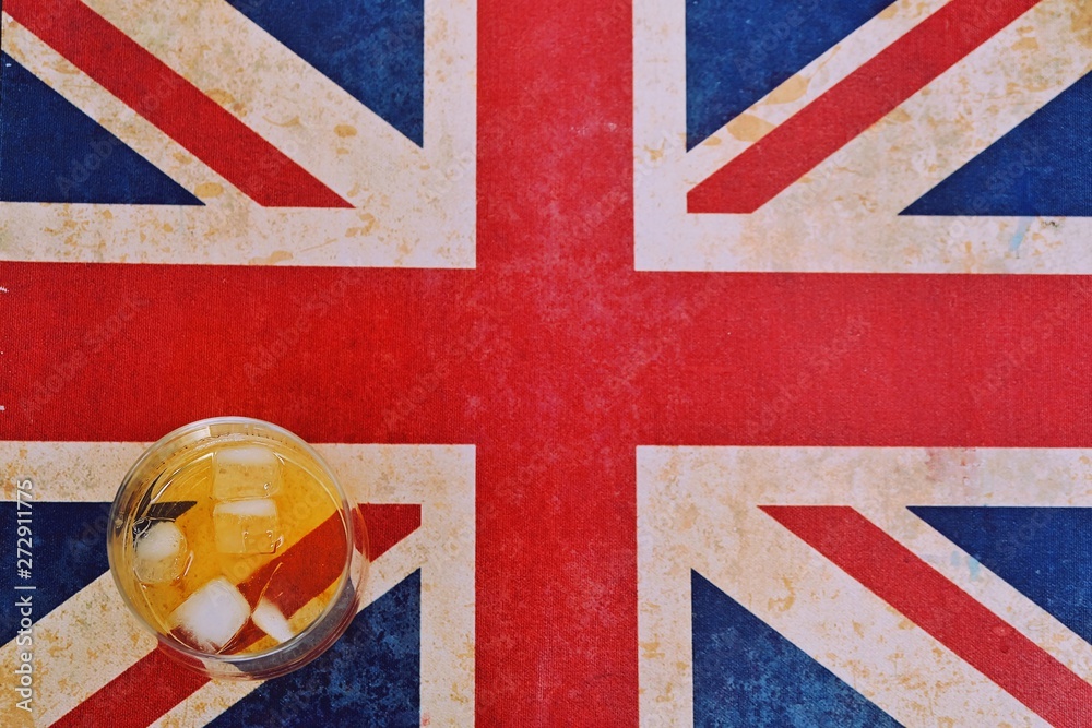 Fototapeta premium a cold glass of whiskey on Union Jack, england flag