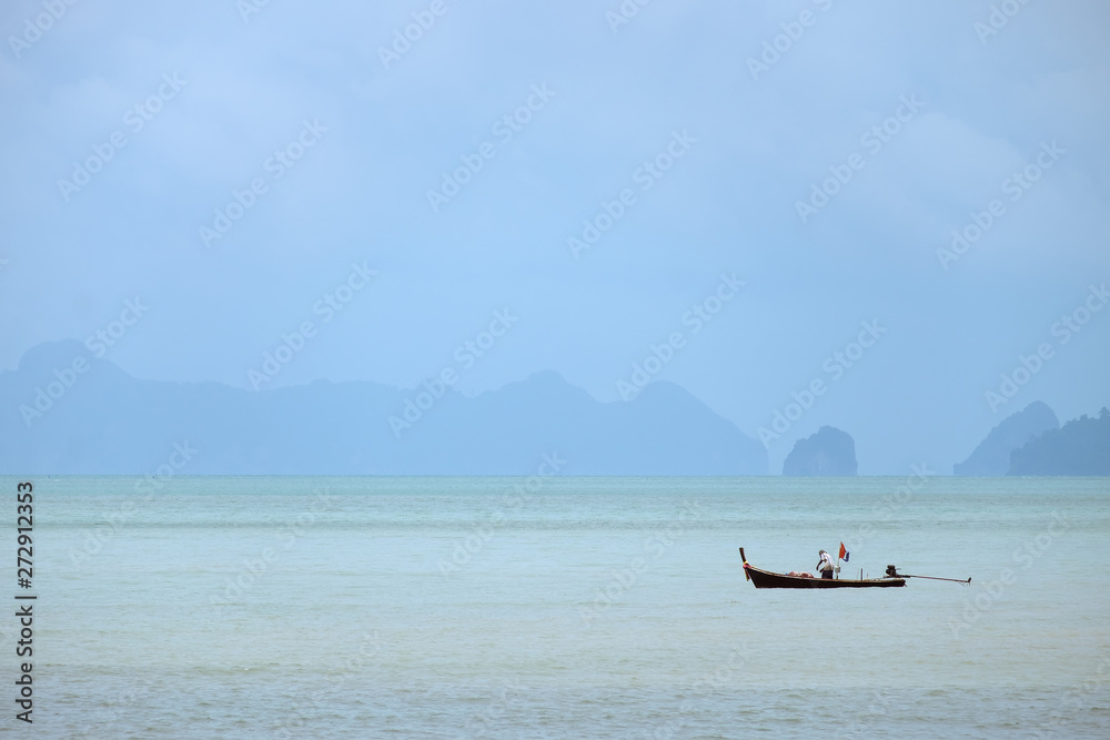 KRABI,THAILAND-AUGUST 18, 2018 : Lifestyle of local fisherman,the fisherman is standing on his small fishing boat and doing something about his occupation in a sea
