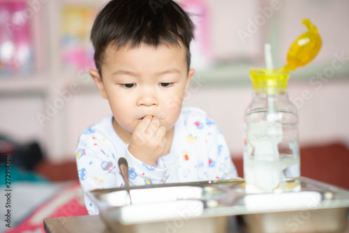 Little toddler boy having breakfast before school at home