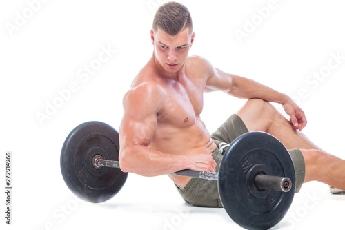 Muscular man working out in studio doing exercises with barbell at biceps, strong male naked torso abs. Isolated on white background. Copy Space. Rest, Sits on the floor at the barbell. Fatigue.