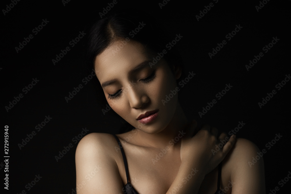 beautiful young woman closeup face and glossy skin under glamour low key concept