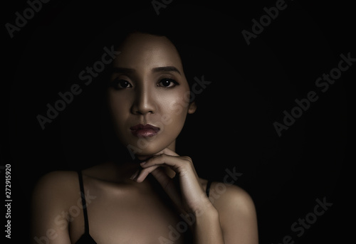 beautiful young woman closeup face and glossy skin under glamour low key concept