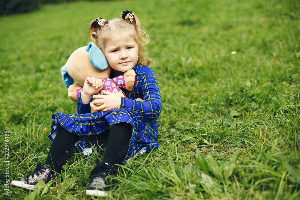 Cute little girl in a park. Child in a blue dress Cute little girl in a park. Child in a blue dress
