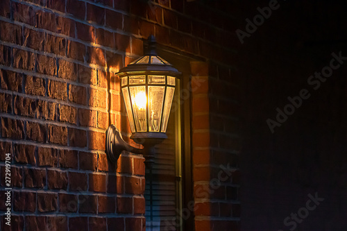 old fashoned glass wall mounted lantern on a brick wall photo