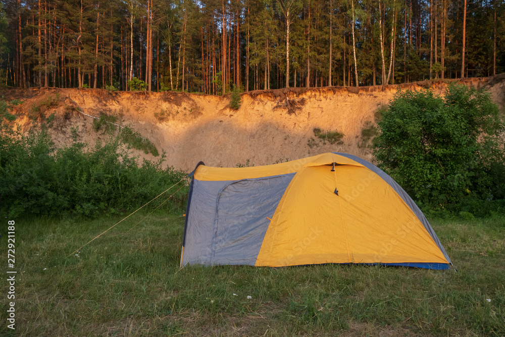 Photography in the evening hour of nature in the summer on a sunny day. Tent for travel.