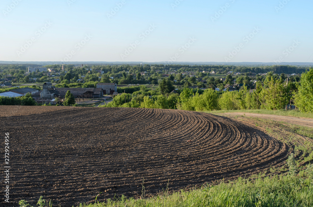 agriculture plowed field and blue sky with clouds in sunset