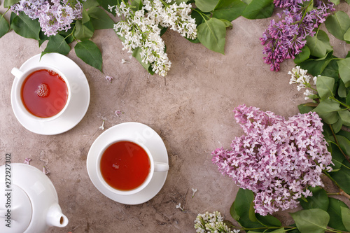 Tea set and flower decor on a textural background. Textural background with flowers and tea pair and place under the text. View from above. Flat lay. The concept of tea drinking. photo