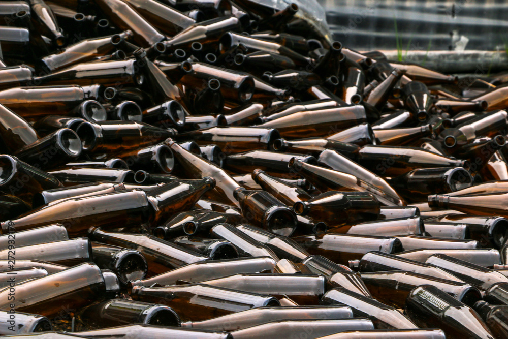 whole and broken brown bottles are scattered on gravel.Concept: waste recycling, disposal of garbage whole and broken brown bottles are scattered on gravel.Concept: waste recycling, disposal of garbage