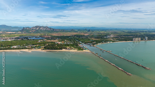 Aerial photo of Cha-am pier in Phetchaburi Province, Thailand shows many fishing boats parked at the port, preparing to go to catch fish in the blue sea on a sunny day