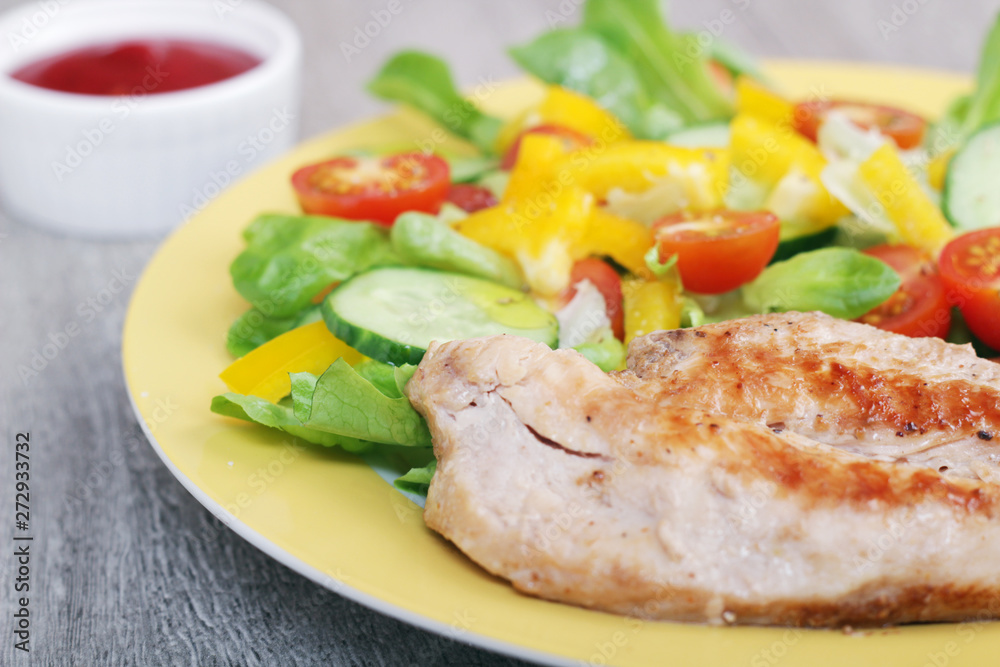 Grilled chicken breast with raw vegetables salad	