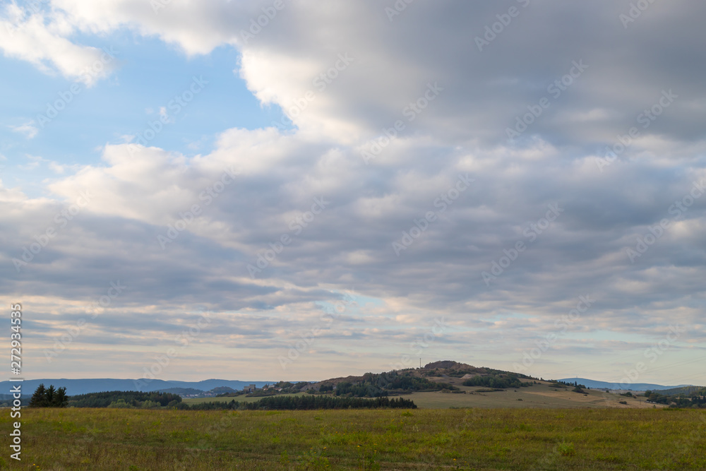 Beautiful sky with clouds over field and mountain Beautiful sky with clouds over field and mountain