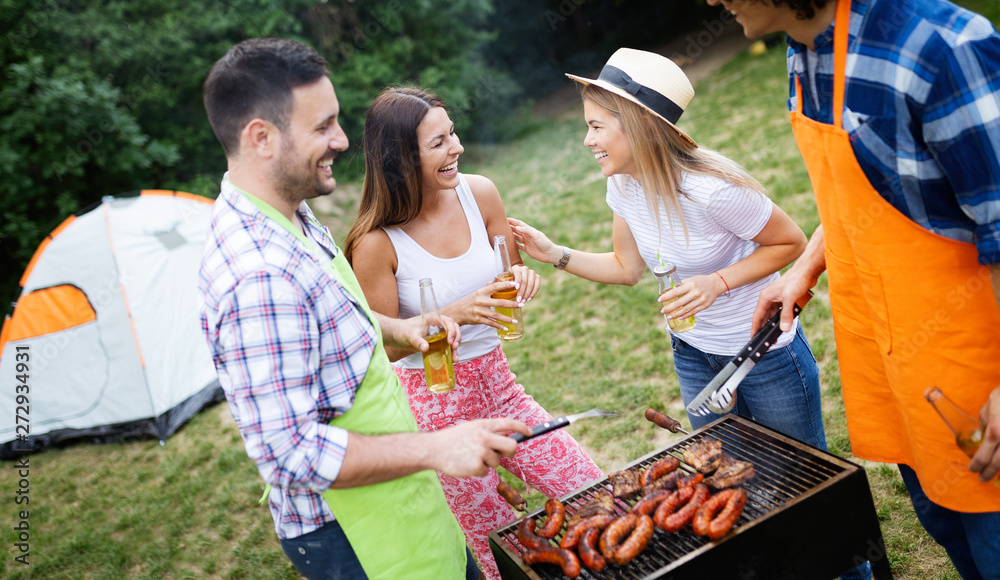 Obraz premium Group of happy friends having a barbecue party in nature