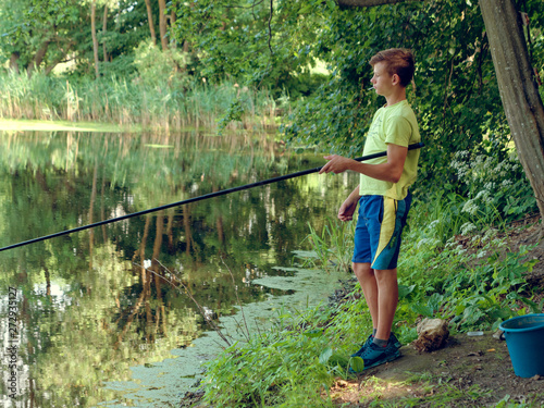 teen child catches a fishing rod on the pond.