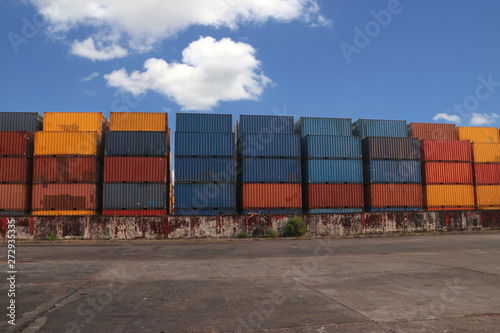Shipping Containers placed as layered in the storage facility on blue sky background.