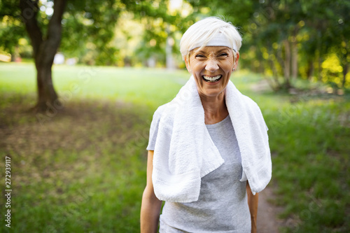 Portrait of smiling sporty senior woman with towel outdoor
