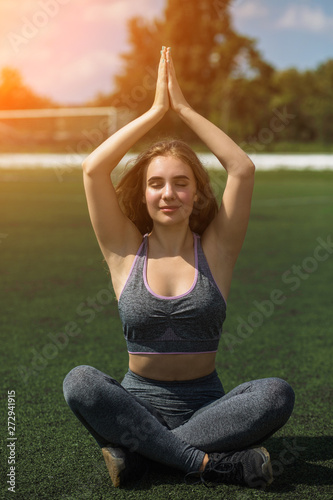 Young sportive girl with curly hairstyle on summer stadium