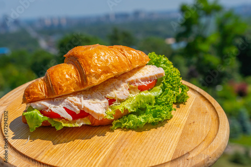 Sweet croissant with fish and chicken ,salad , vegetables . Fresh morning breakfast