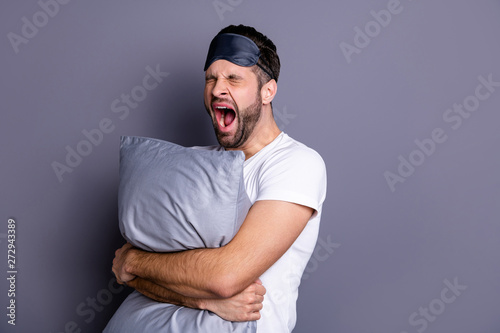 Portrait of his he nice-looking attractive exhausted sleepy bearded guy holding in hands pillow drowsiness going to bed isolated over gray pastel violet purple background photo
