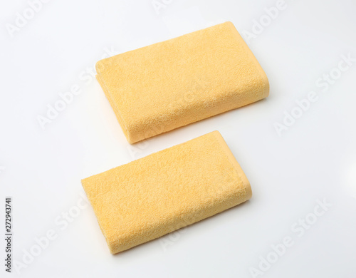 Two beige terry towels folded on a white background