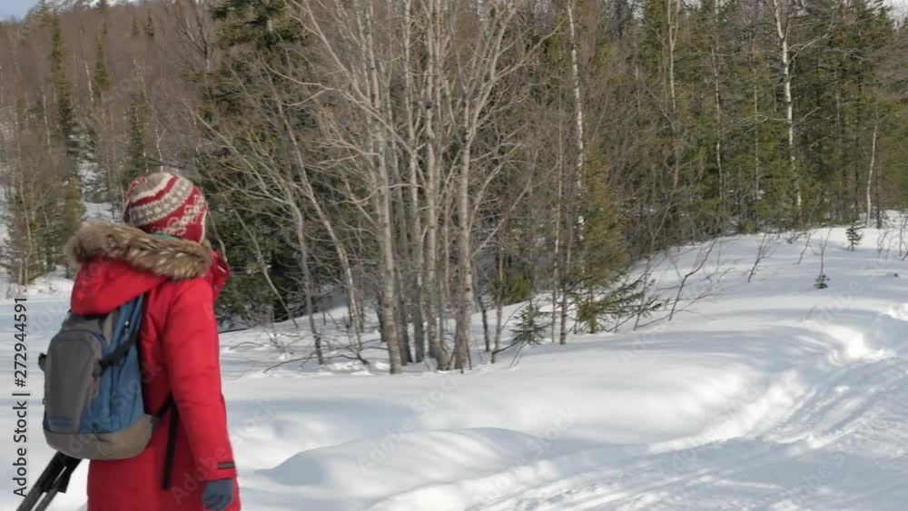tourist with blue and grey backpack walks along snowy road